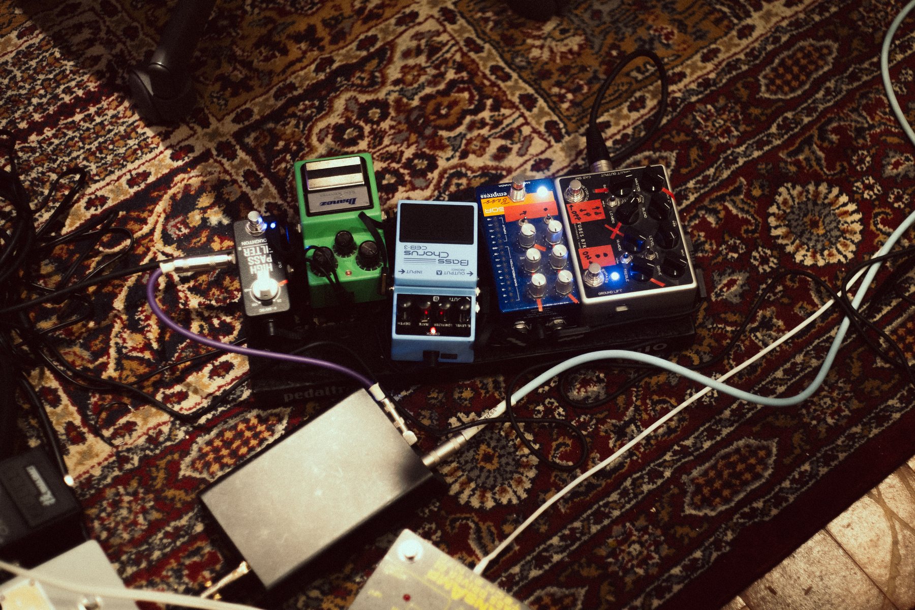 The band's pedalboard set up on a patterned rug